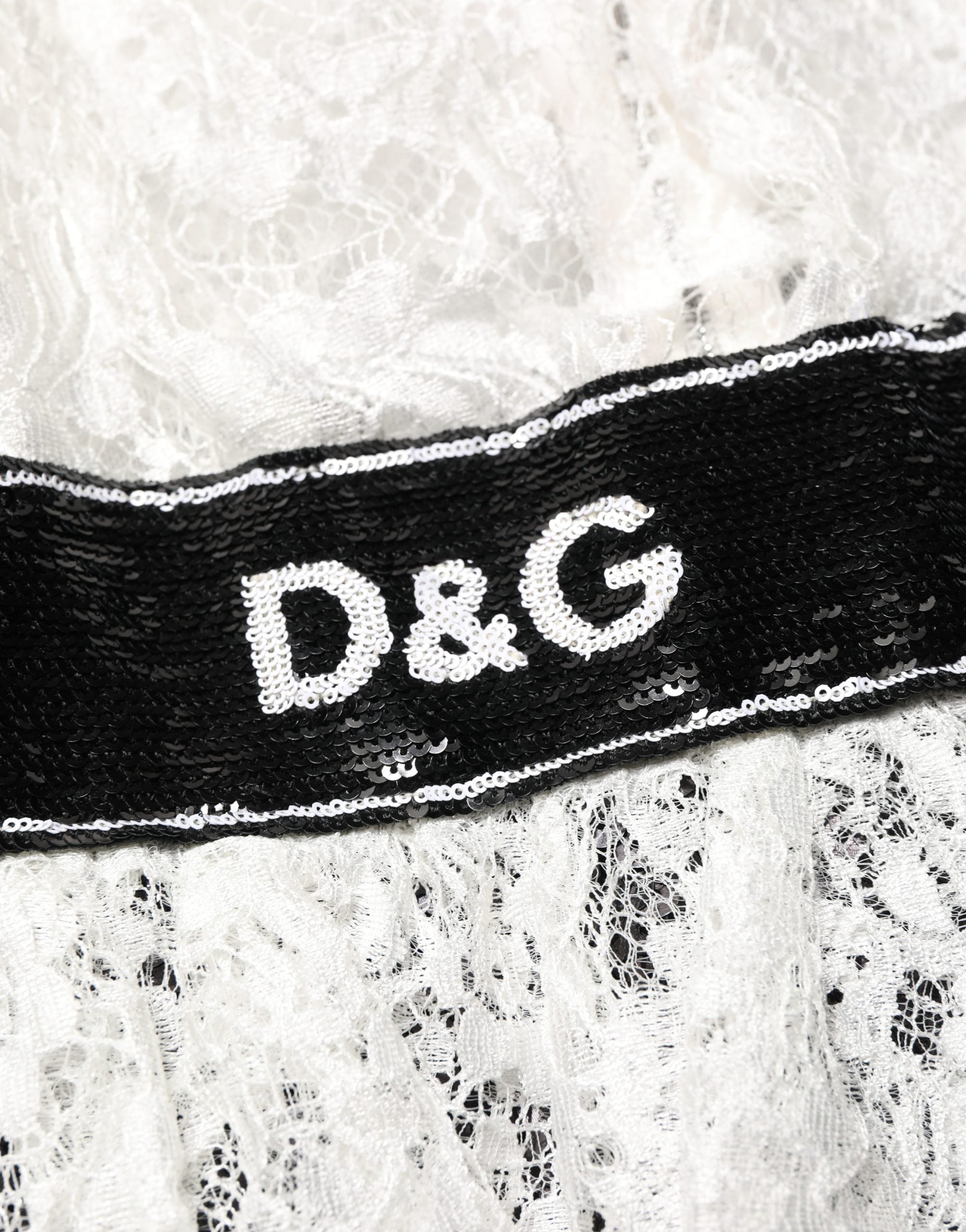 Dolce & Gabbana Kleid aus weißer Spitze mit schwarzem Rock und Verzierungen